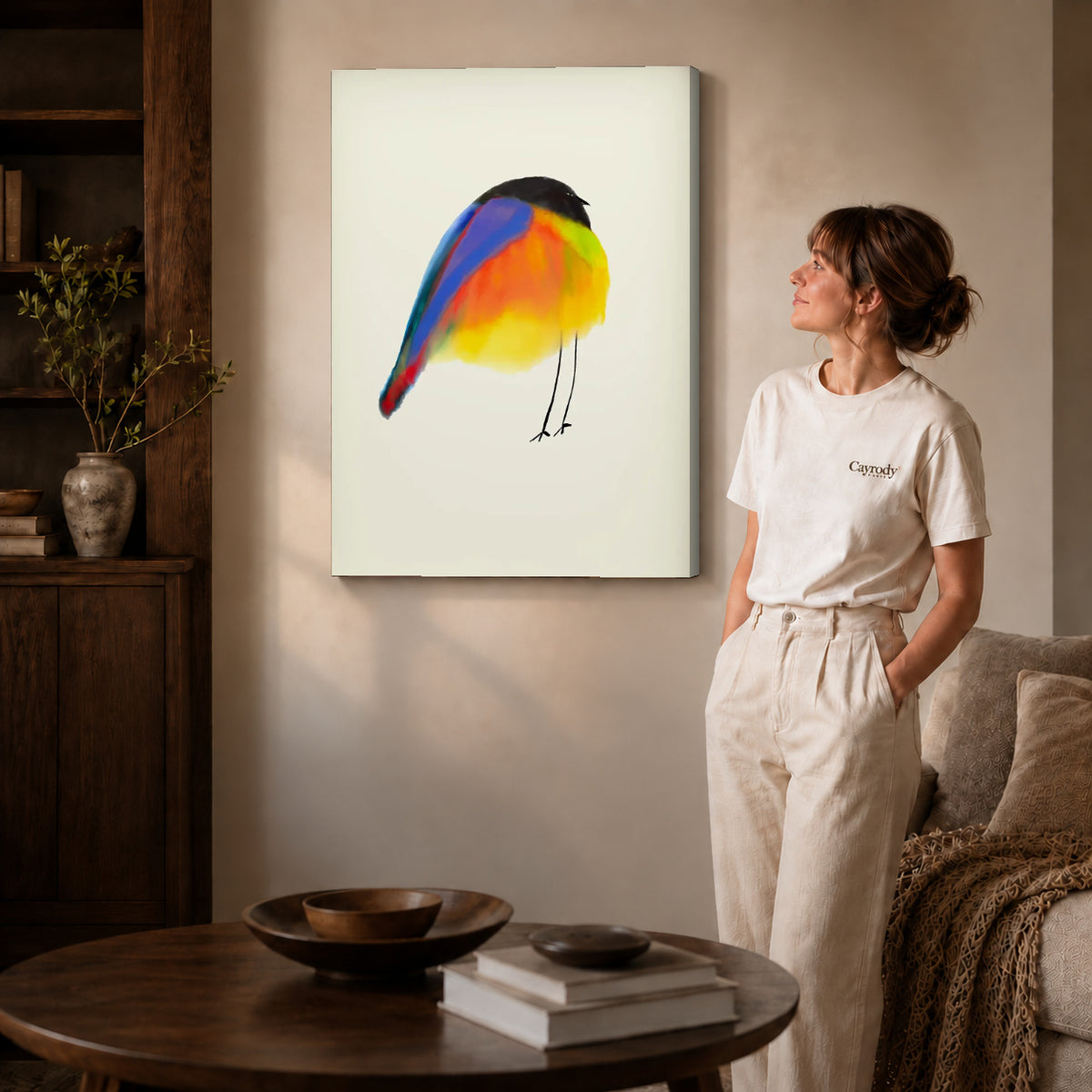 Colorful Bird canvas art displayed as gallery wrapped canvas beside a woman in natural light.