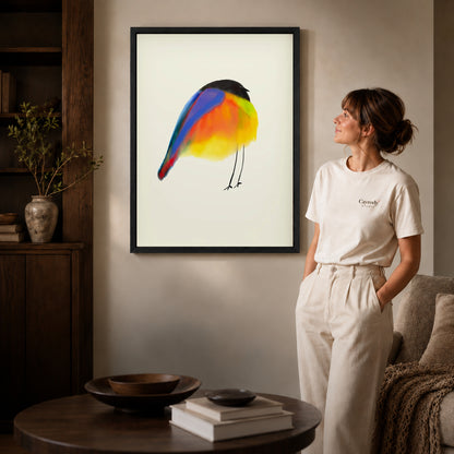 Black framed colorful bird canvas art displayed beside a woman in a warm living room.