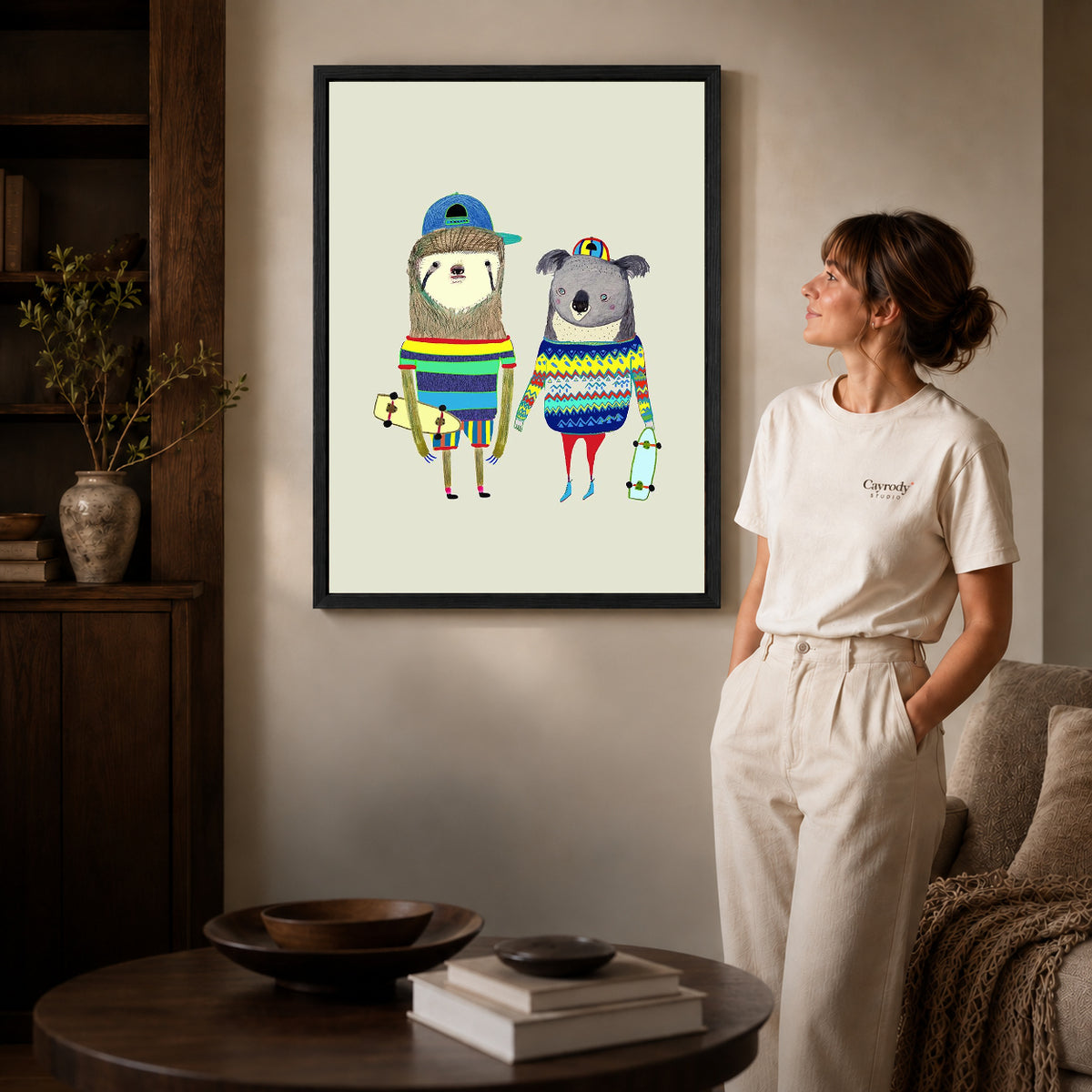 Black framed skateboard friends canvas art displayed beside a woman in a warm living room.