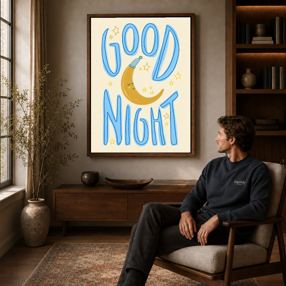 good night moon art canvas art in a walnut frame above a console beside a seated man.
