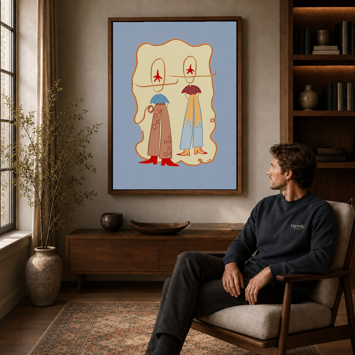 Western Cowgirl Duo canvas art above a wooden console beside a seated man in a warm room.