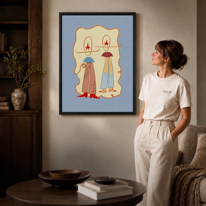 Black framed western cowgirl duo canvas art displayed beside a woman in a warm living room.