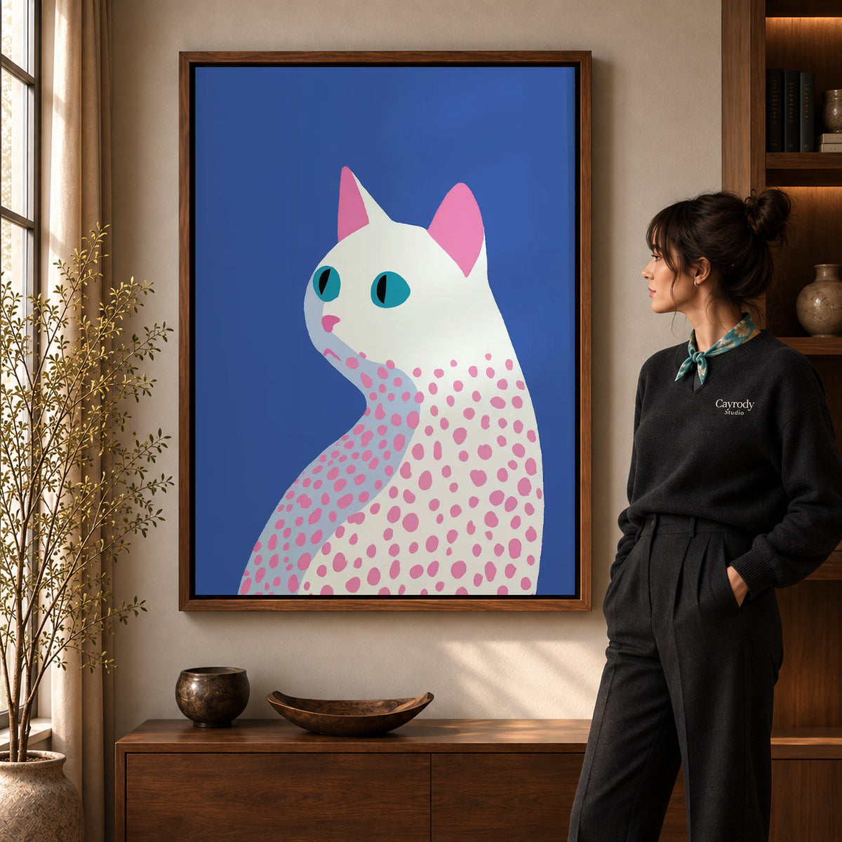 Walnut framed spotted cat canvas art shown beside a standing woman and a wooden console.