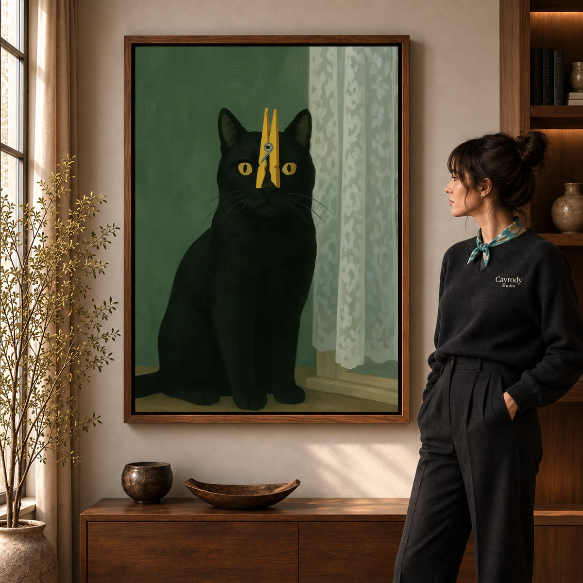 Walnut framed clothespin cat canvas art shown beside a standing woman and a wooden console.