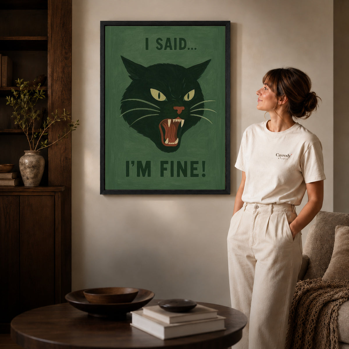 Black framed grumpy cat canvas art displayed beside a woman in a warm living room.