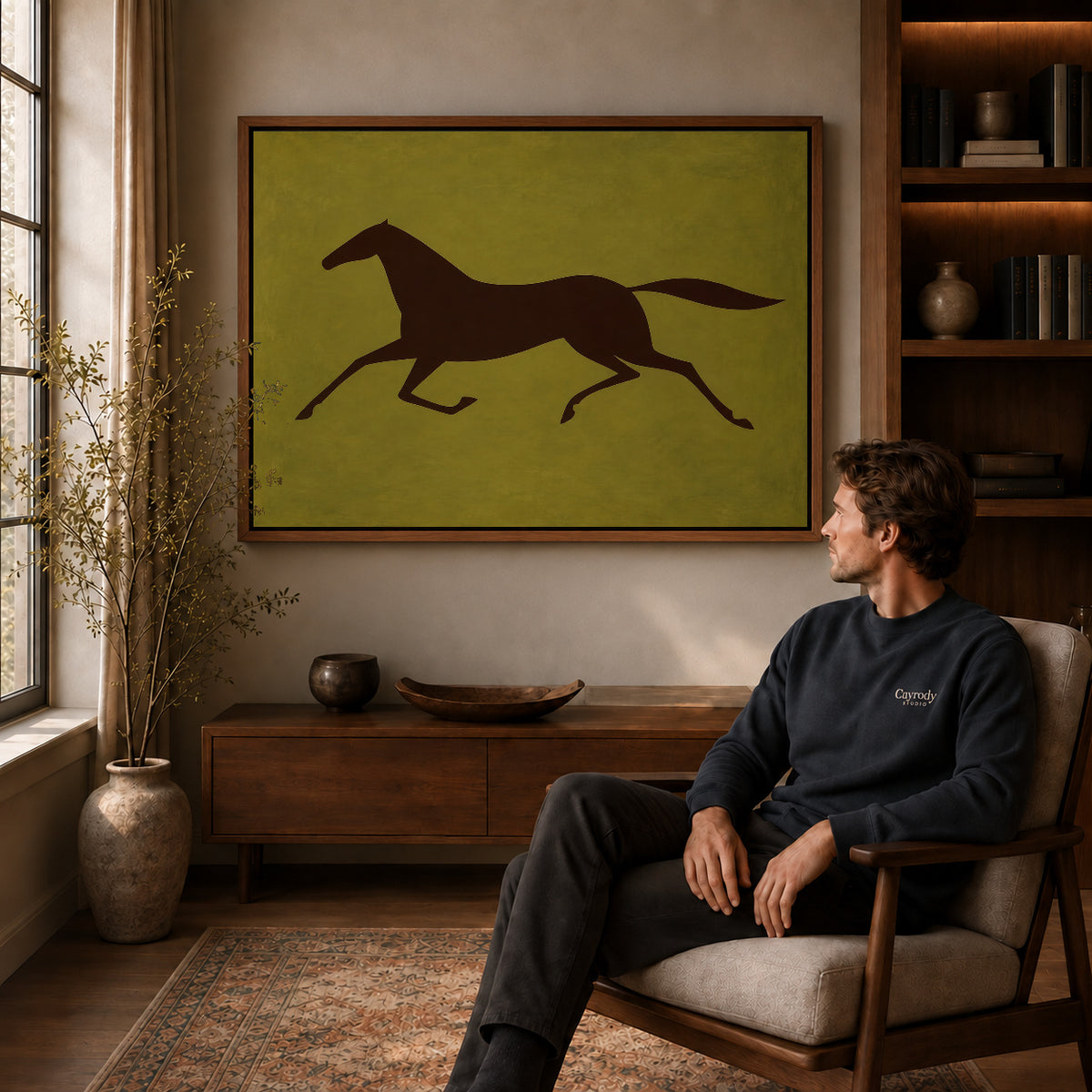Galloping Horse canvas art above a wooden console beside a seated man in a warm room.