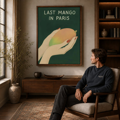 Last Mango canvas art above a wooden console beside a seated man in a warm room.