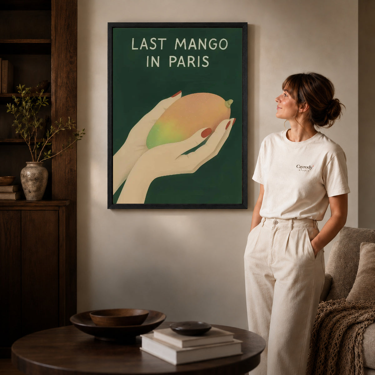 Last Mango canvas art in a black frame above books in a welcoming living room.