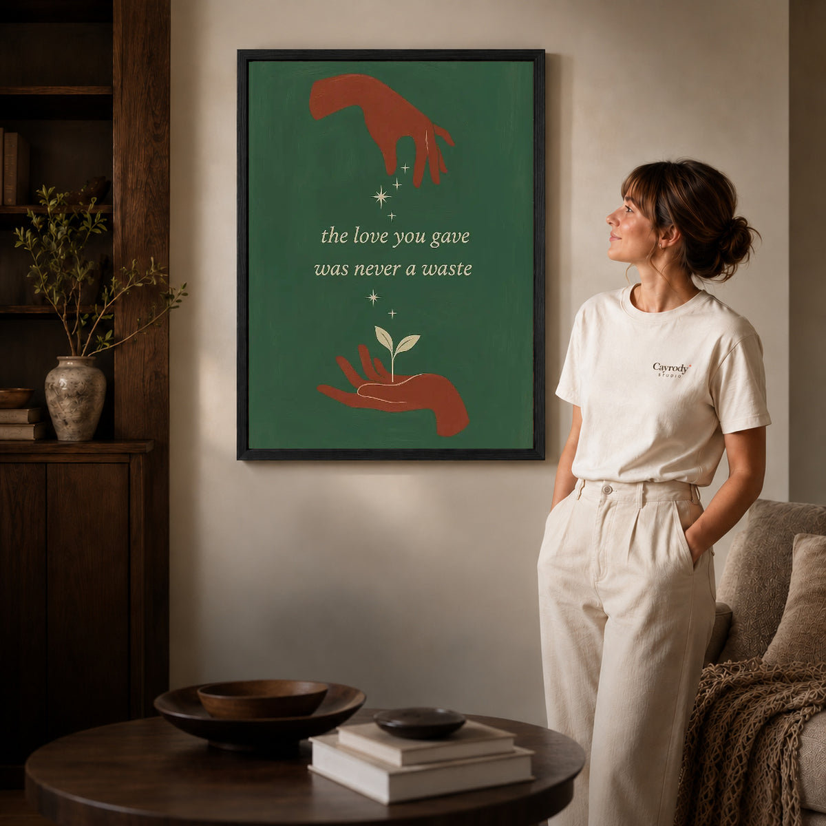 Growing Love canvas art in a black frame above books in a welcoming living room.