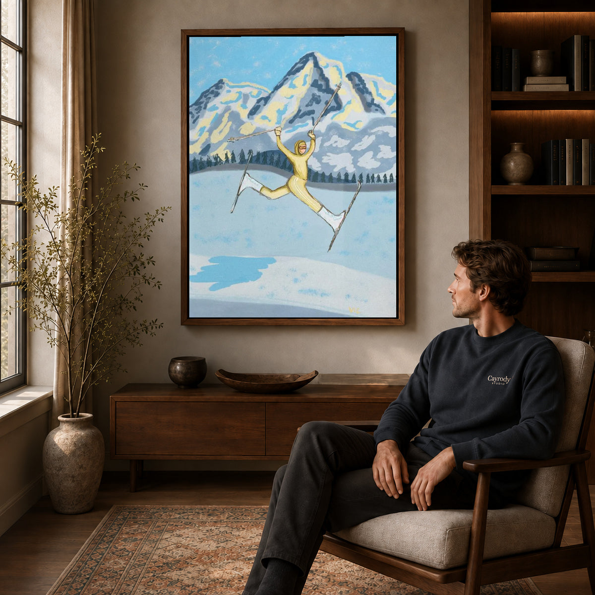 Joyful Skier canvas art above a wooden console beside a seated man in a warm room.