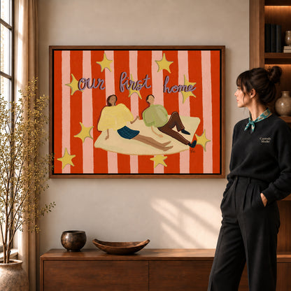 First Home Couple canvas art in a walnut frame beside a standing woman and wooden console.