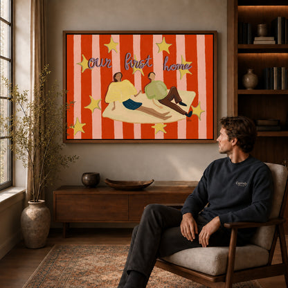 First Home Couple canvas art above a wooden console beside a seated man in a warm room.