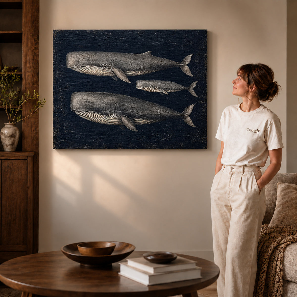 Vintage Whale Trio canvas art displayed as gallery wrapped canvas beside a woman in natural light.