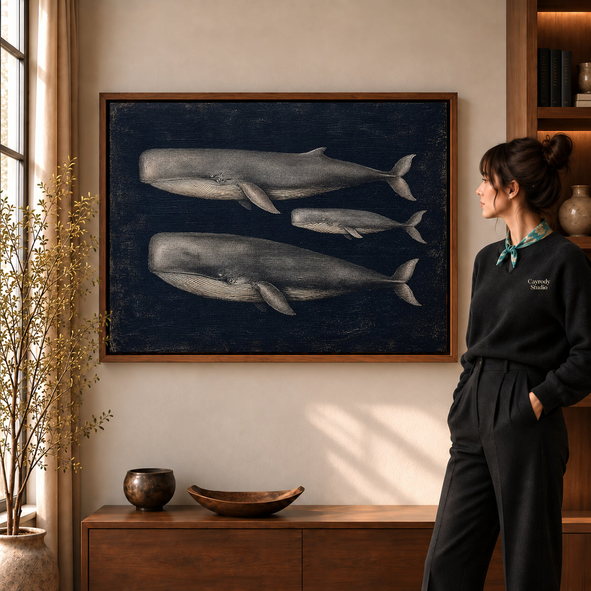 Walnut framed vintage whale trio canvas art shown beside a standing woman and a wooden console.