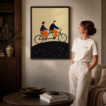 Tandem Ride canvas art in a black frame above books in a welcoming living room.