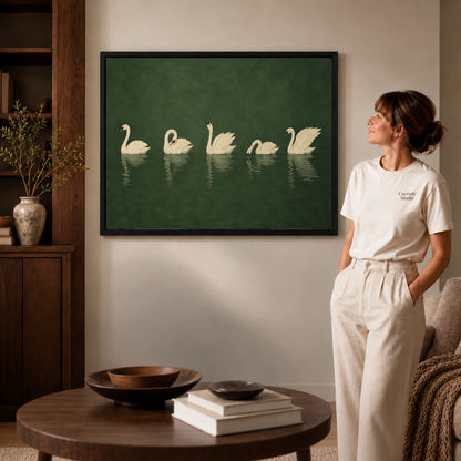 Black framed quiet swan gathering canvas art displayed beside a woman in a warm living room.