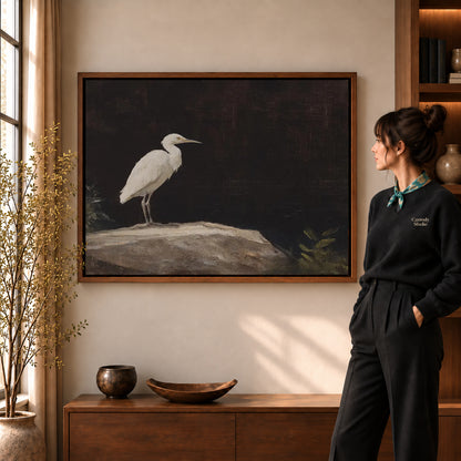 Walnut framed quiet egret canvas art shown beside a standing woman and a wooden console.