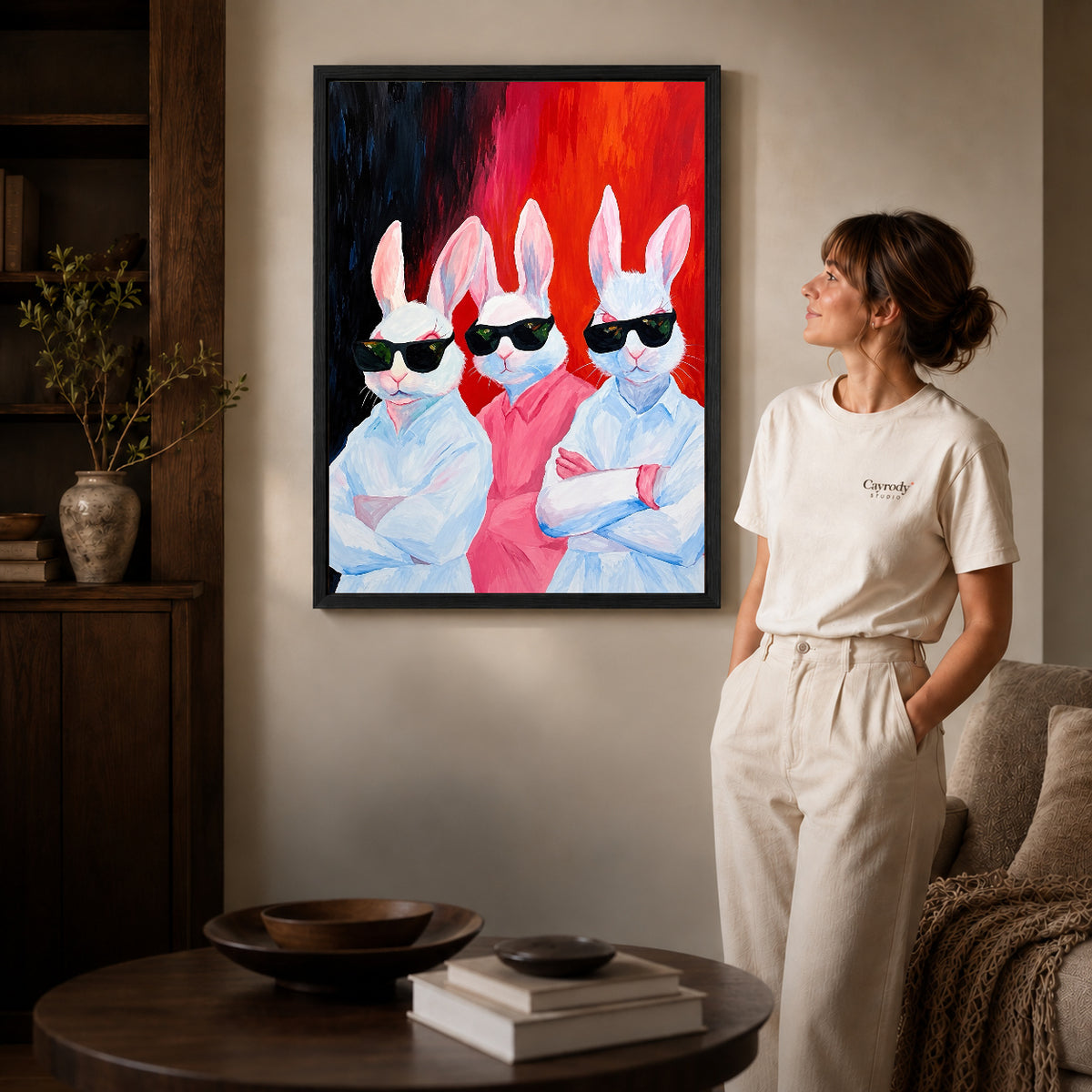 Rabbit Canvas Art inside a black frame in a softly lit living room with books.