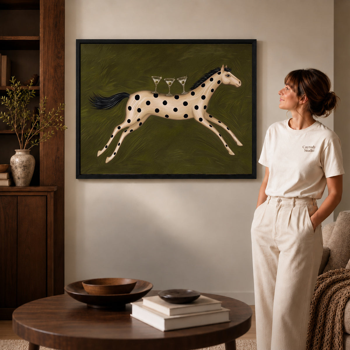 Horse Canvas Art inside a black frame in a softly lit living room with books.
