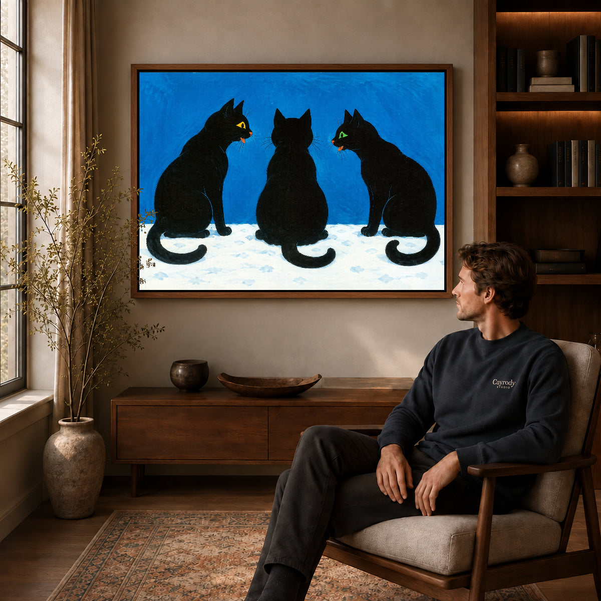 Black Cat Canvas Art displayed in a walnut frame above wooden furniture beside a seated man.