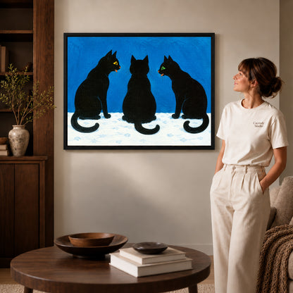 Black Cat Canvas Art inside a black frame in a softly lit living room with books.