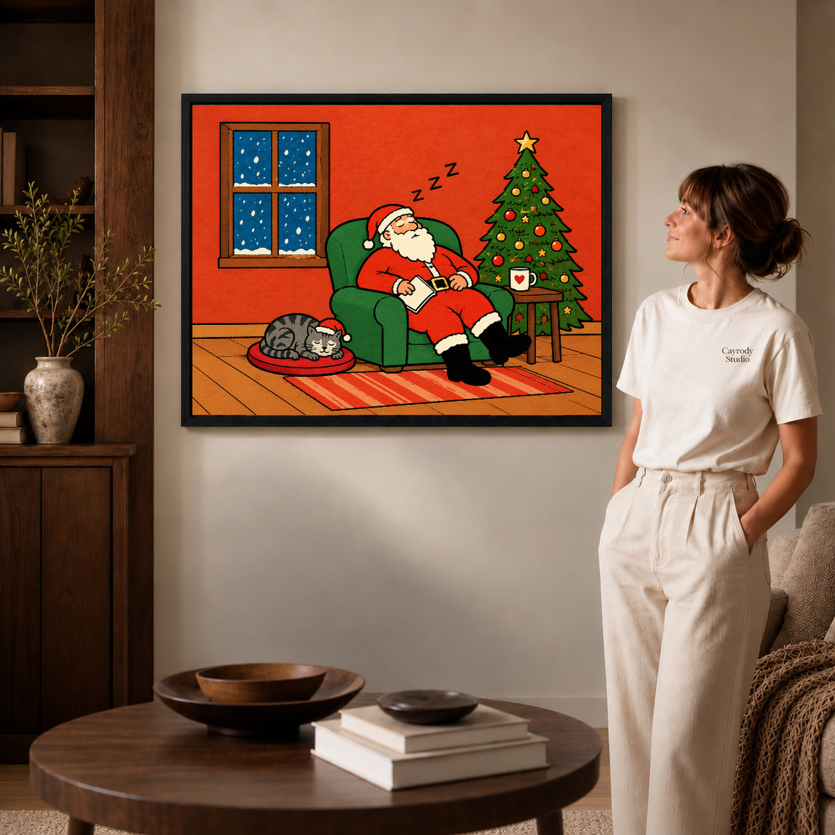 Santa Canvas Art inside a black frame in a softly lit living room with books.