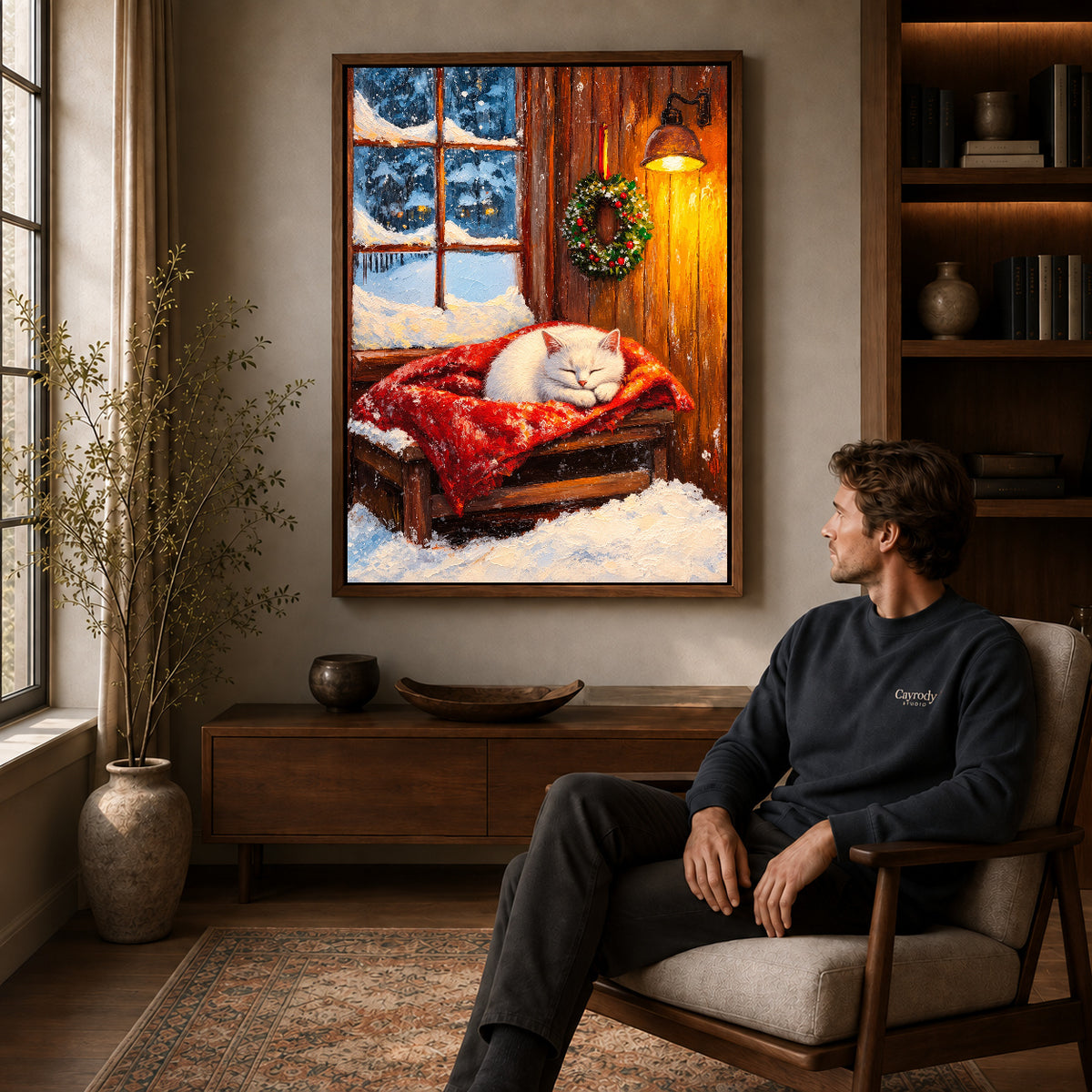 Winter Kitten Canvas Art displayed in a walnut frame above wooden furniture beside a seated man.