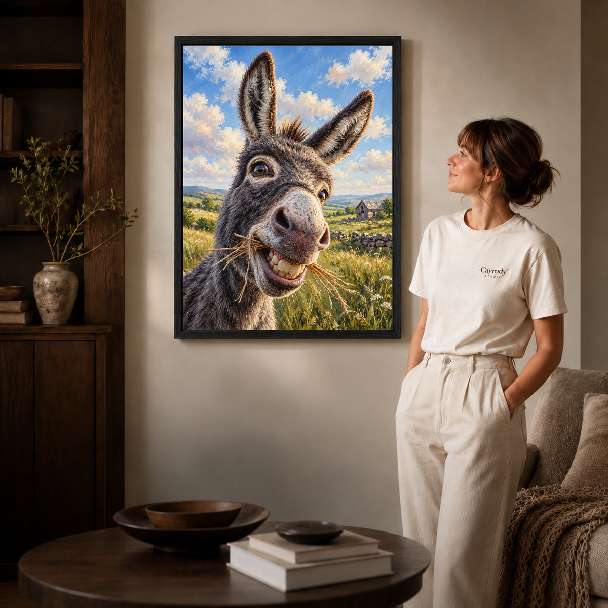 Donkey Canvas Art inside a black frame in a softly lit living room with books.