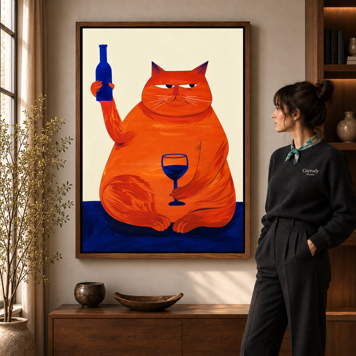 Funny Cat Canvas Art in a walnut frame beside a standing woman and warm wooden furniture.