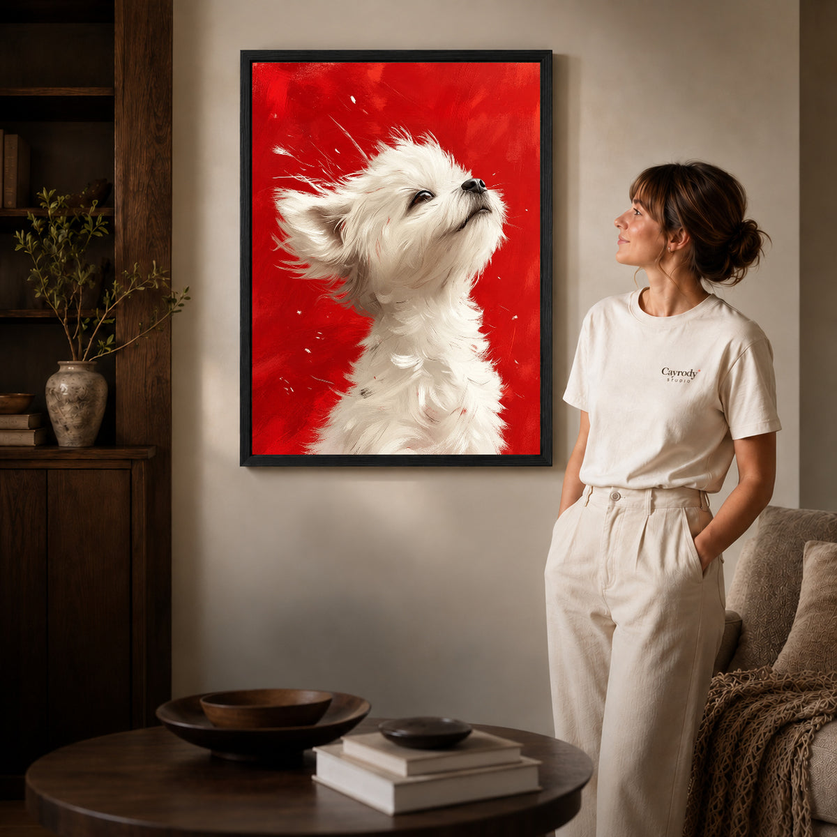 White Puppy Canvas Art inside a black frame in a softly lit living room with books.