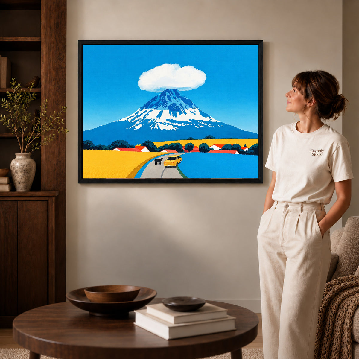 Black framed mount fuji canvas art displayed beside a woman with natural light across the wall.