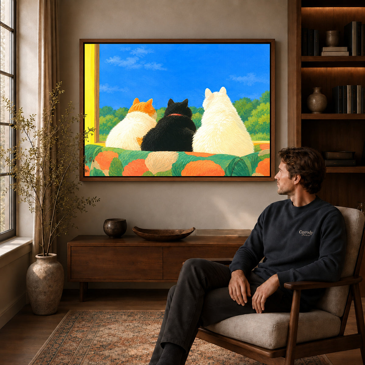 Window Cats Canvas Art displayed in a walnut frame above wooden furniture beside a seated man.