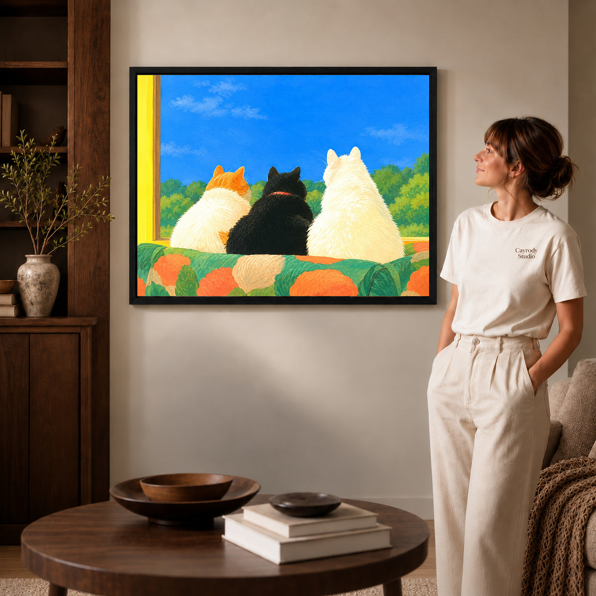 Black framed window cats canvas art displayed beside a woman with natural light across the wall.