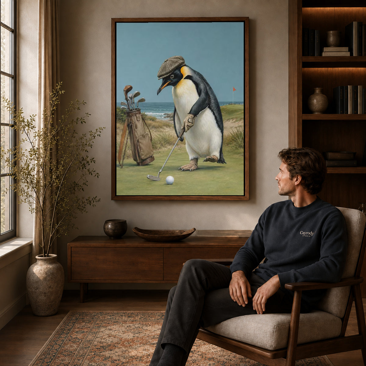 Golf Penguin Canvas Art displayed in a walnut frame above wooden furniture beside a seated man.