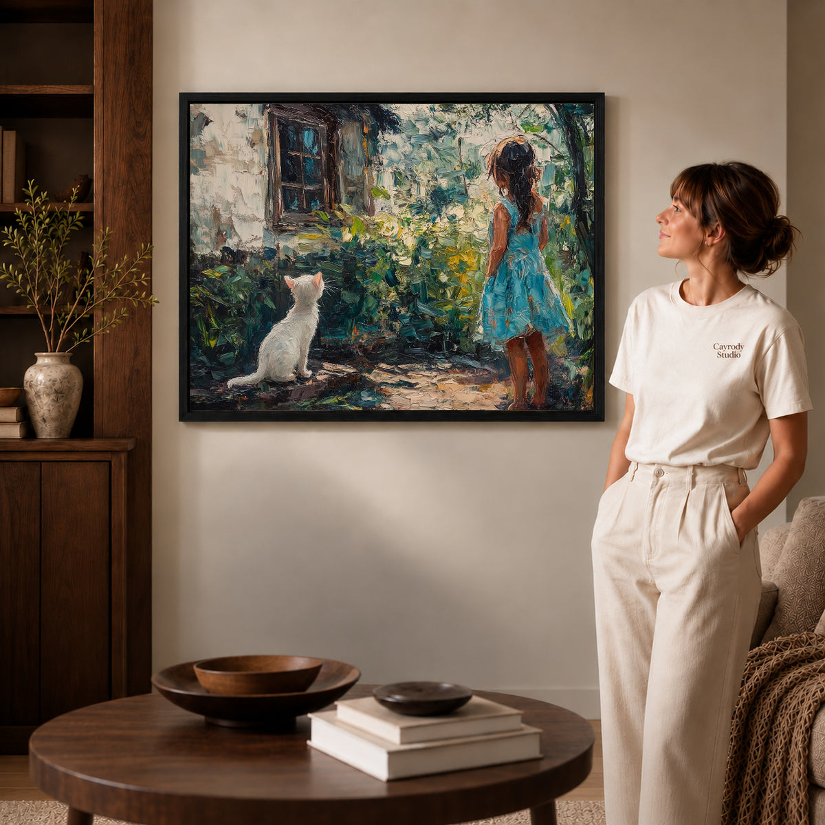 Garden Cat Canvas Art inside a black frame in a softly lit living room with books.
