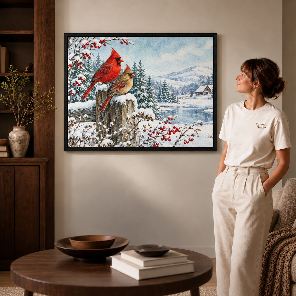 Cardinal Canvas Art inside a black frame in a softly lit living room with books.