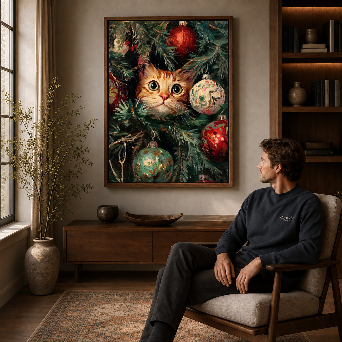Christmas Kitten Canvas Art displayed in a walnut frame above wooden furniture beside a seated man.