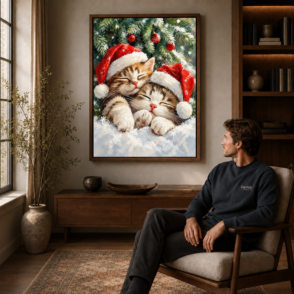 Christmas Kittens Canvas Art displayed in a walnut frame above wooden furniture beside a seated man.