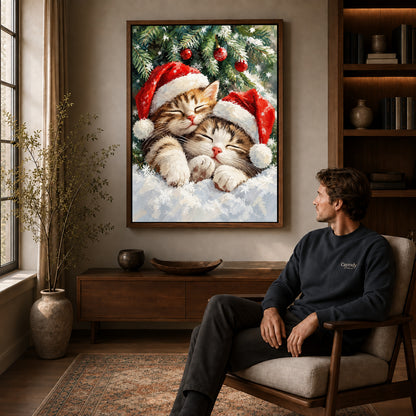 Christmas Kittens Canvas Art displayed in a walnut frame above wooden furniture beside a seated man.