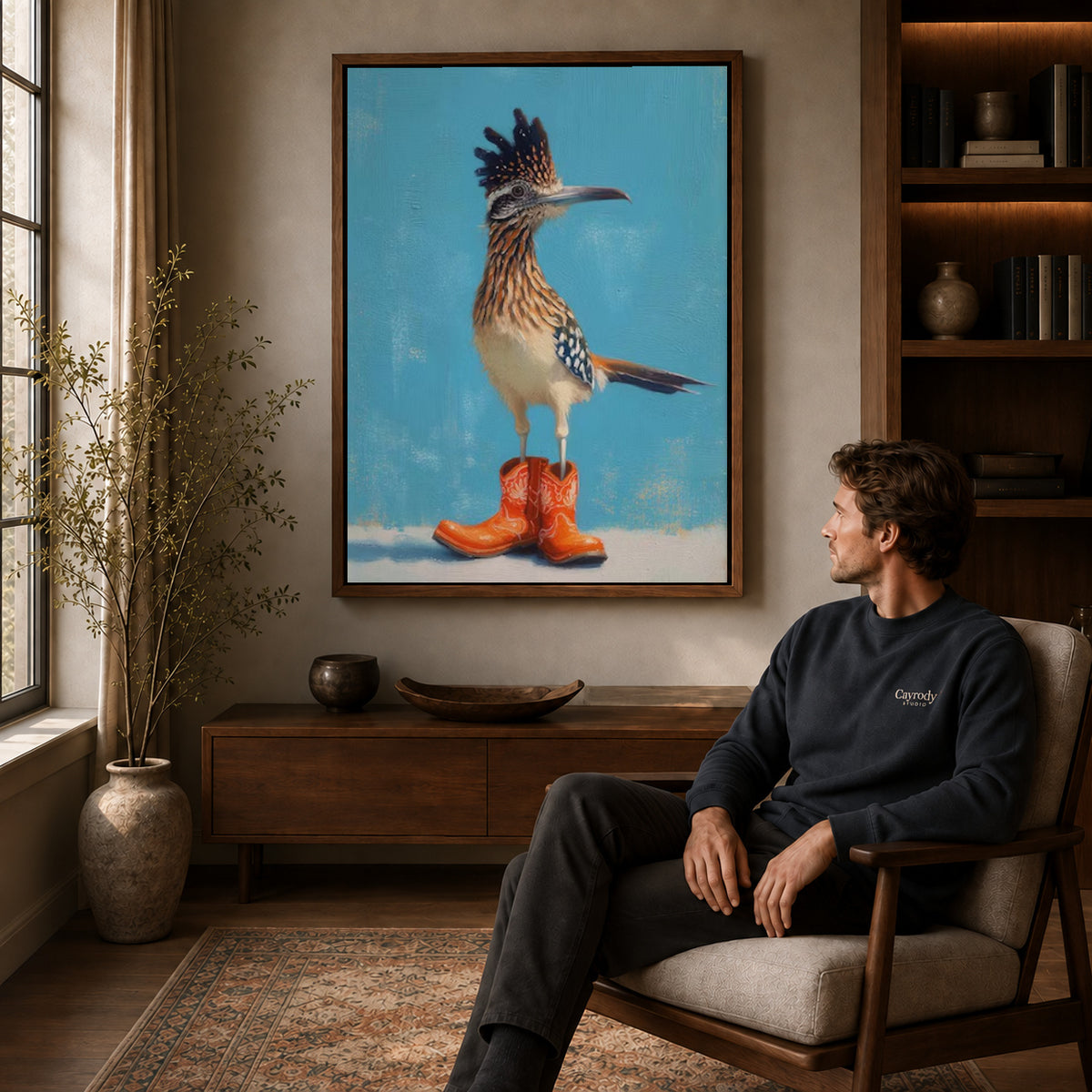 Roadrunner Canvas Art displayed in a walnut frame above wooden furniture beside a seated man.