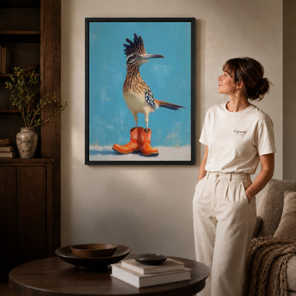 Black framed roadrunner canvas art displayed beside a woman with natural light across the wall.