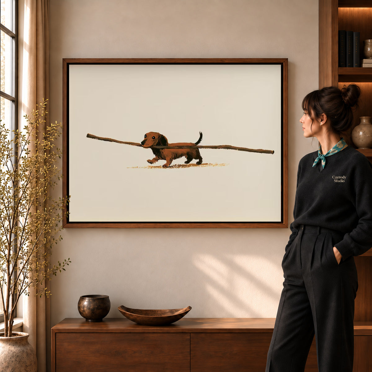 Dachshund Canvas Art in a walnut frame beside a standing woman and warm wooden furniture.