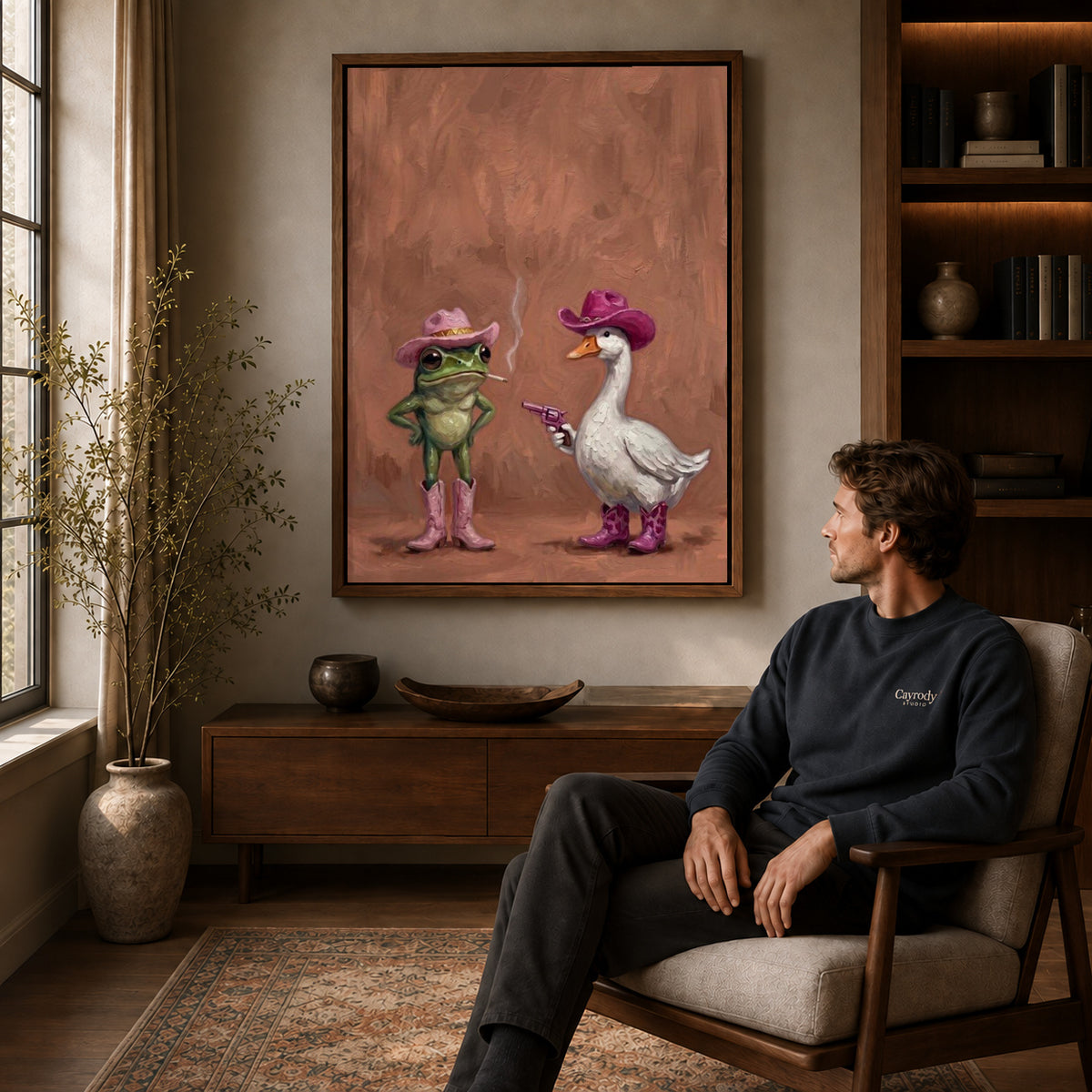 Frog Goose Canvas Art displayed in a walnut frame above wooden furniture beside a seated man.
