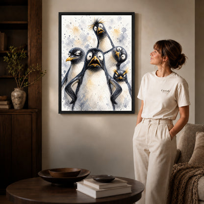 Black framed funny penguins canvas art displayed beside a woman with natural light across the wall.