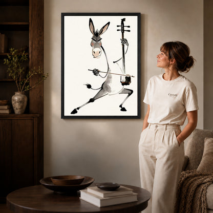 Black framed musical donkey canvas art displayed beside a woman with natural light across the wall.