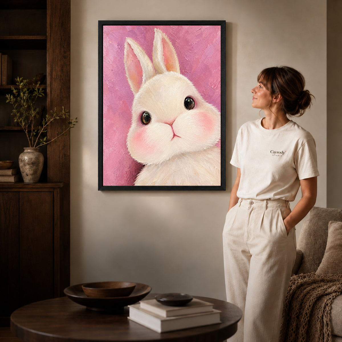 Bunny Canvas Art inside a black frame in a softly lit living room with books.