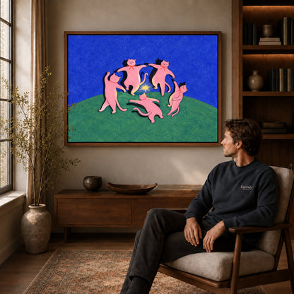 Dancing Cats Canvas Art displayed in a walnut frame above wooden furniture beside a seated man.