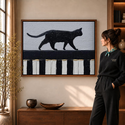 Piano Cat Canvas Art in a walnut frame beside a standing woman and warm wooden furniture.