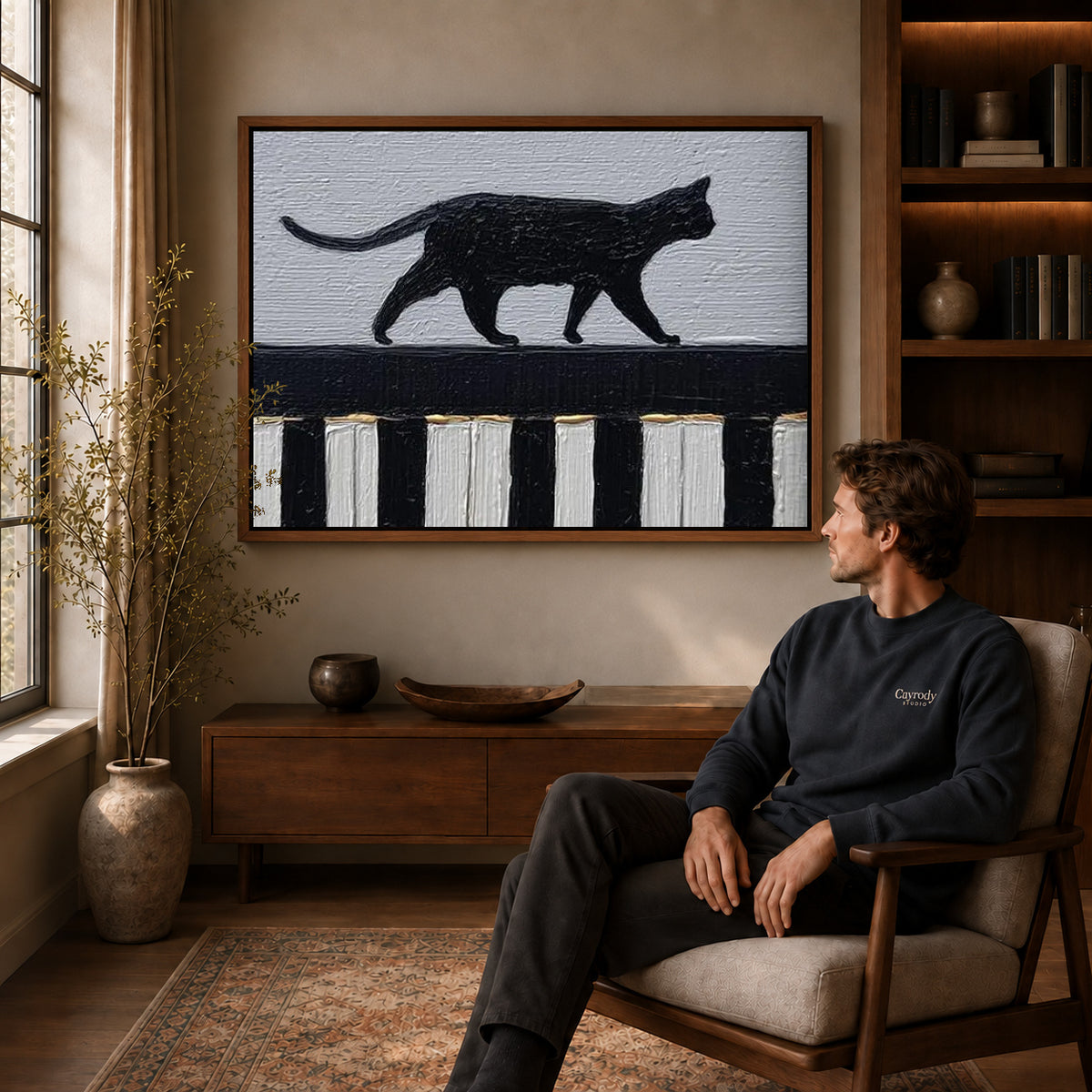 Piano Cat Canvas Art displayed in a walnut frame above wooden furniture beside a seated man.