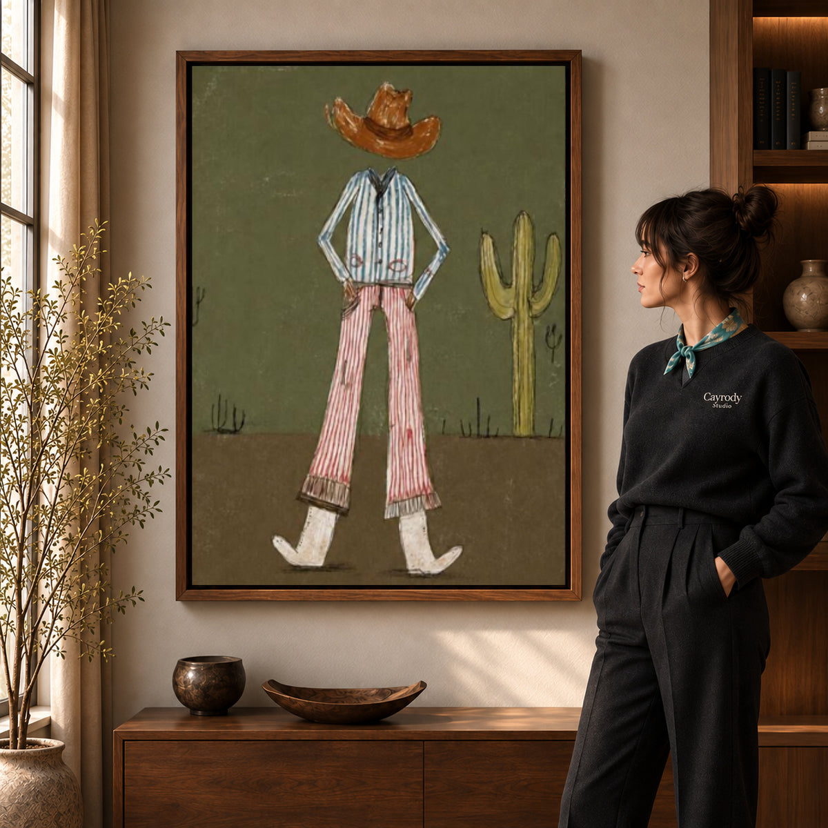 Cowboy Canvas Wall Art in a walnut frame beside a standing woman and warm wooden furniture.